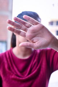 Close-up of woman covering face with hand