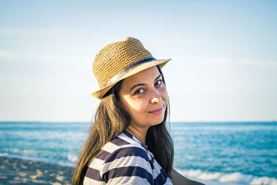 Portrait of smiling young woman against sea against sky