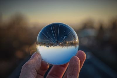 Cropped hand of person holding crystal ball