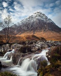 Scenic view of waterfall against sky