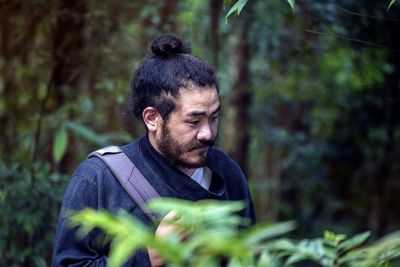 Man looking at camera in forest