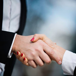 Close-up of business colleagues shaking hands in city
