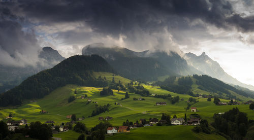 Scenic view of green landscape and mountains against sky
