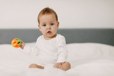 Portrait of cute baby boy on bed