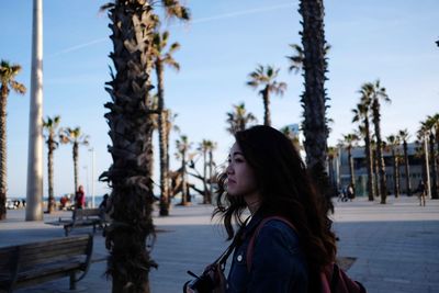 Portrait of young woman looking at trees