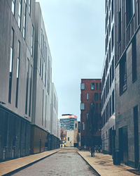 Street amidst buildings against sky in city