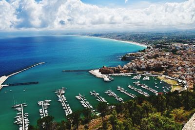 High angle view of sea and cityscape against sky