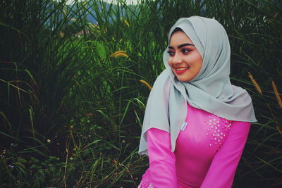 Portrait of a smiling young woman standing outdoors