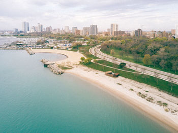 High angle view of sea by city against sky