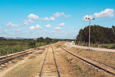 Railroad track amidst trees against sky