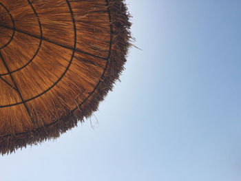 Low angle view of under a parasol against clear sky