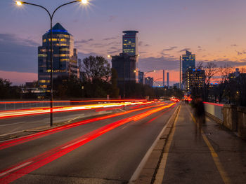 Light trails on road against sky at sunset