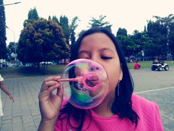 Girl blowing bubble at park