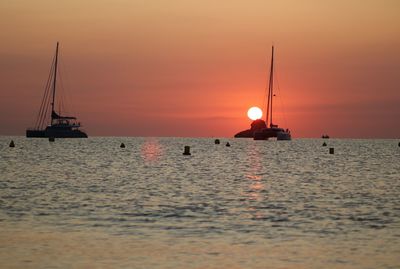 Sailboat sailing on sea against romantic sky at sunset