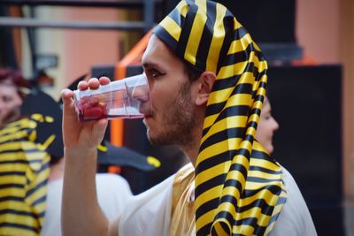 Midsection of man holding drink drinking glass