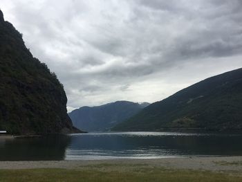 Scenic view of mountains and lake against cloudy sky
