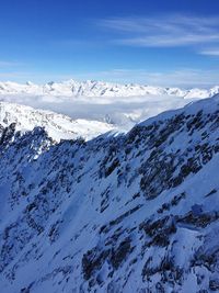 Scenic view of snowcapped mountains against blue sky