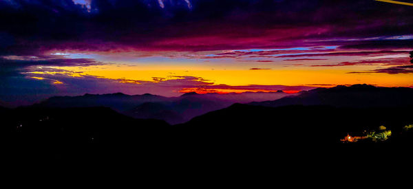 Scenic view of silhouette mountains against romantic sky at sunset