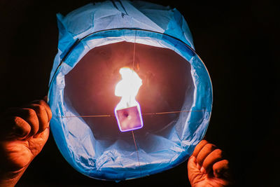 Midsection of person holding burning candle