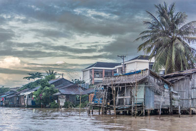 Houses by sea against sky