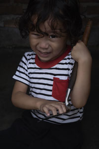 Portrait of boy holding tool while sitting in darkroom