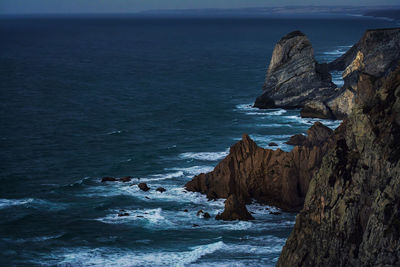 Rock formation in sea against sky