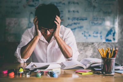 Tensed male student studying at desk