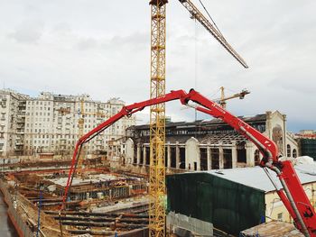 Cranes at construction site against sky