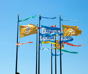 Low angle view of flag against clear blue sky