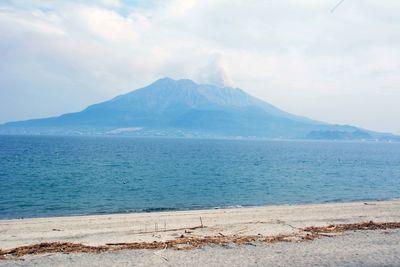 Scenic view of sea and mountains against sky