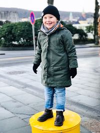 Smiling boy standing on metallic structure 