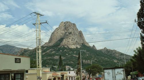 Electricity pylon and mountains against sky