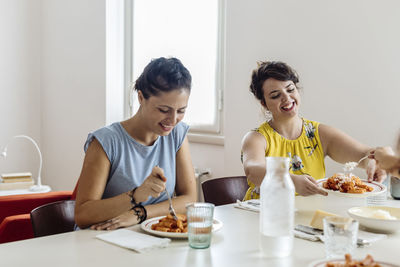 Cheerful women enjoying healthy dinner at home