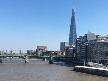 Bridge over river against buildings in city