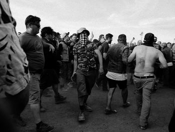 Rear view of people standing in city against sky