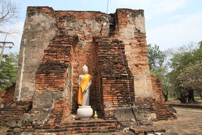 Low angle view of buddha statue against the sky