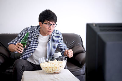 Man eating popcorn while watching tv