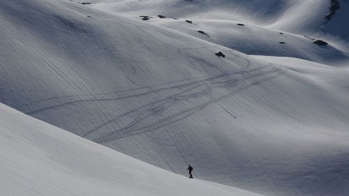 High angle view of people skiing on snow covered landscape