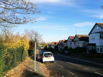 Cars on road in city against sky