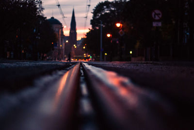 Surface level of empty road along trees at night