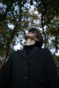 Low angle view of woman standing against trees