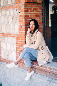 Portrait of woman sitting on wall