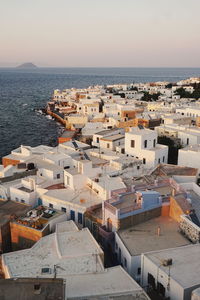 High angle view of town by sea against sky