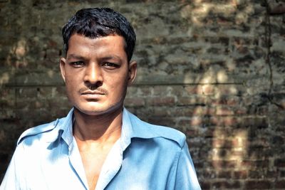 Portrait of serious mature man standing against wall