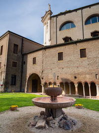 Water fountain in old building against sky