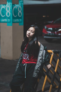 Young woman standing against wall