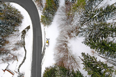 Aerial view of cars on winding road in winter forest