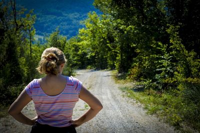 Rear view of woman standing on road