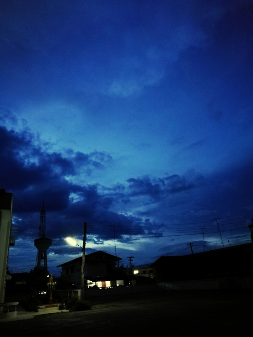 VIEW OF ILLUMINATED STREET LIGHTS AGAINST CLOUDY SKY