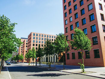 Street by buildings against sky